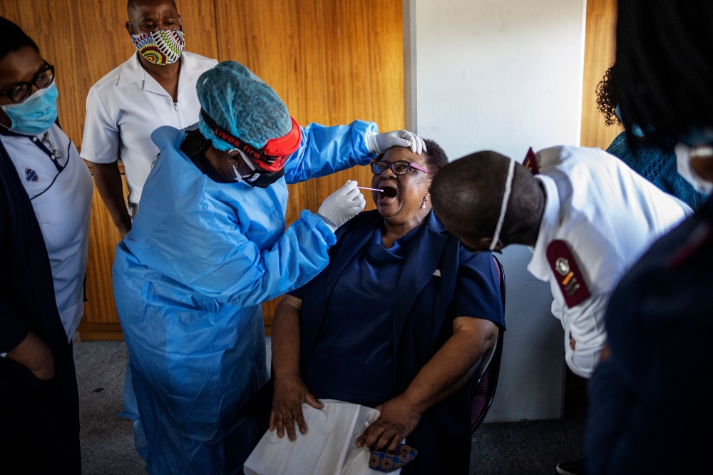 Doctors Without Borders (MSF) nurse Bhelekazi Mdlalose (3rd L), 51, illustrates how to perform a swab test on a nurse participating in a COVID-19 coronavirus training course for nurses at the City of Joburg Civic Centre in Roodeport, Johannesburg, on May 