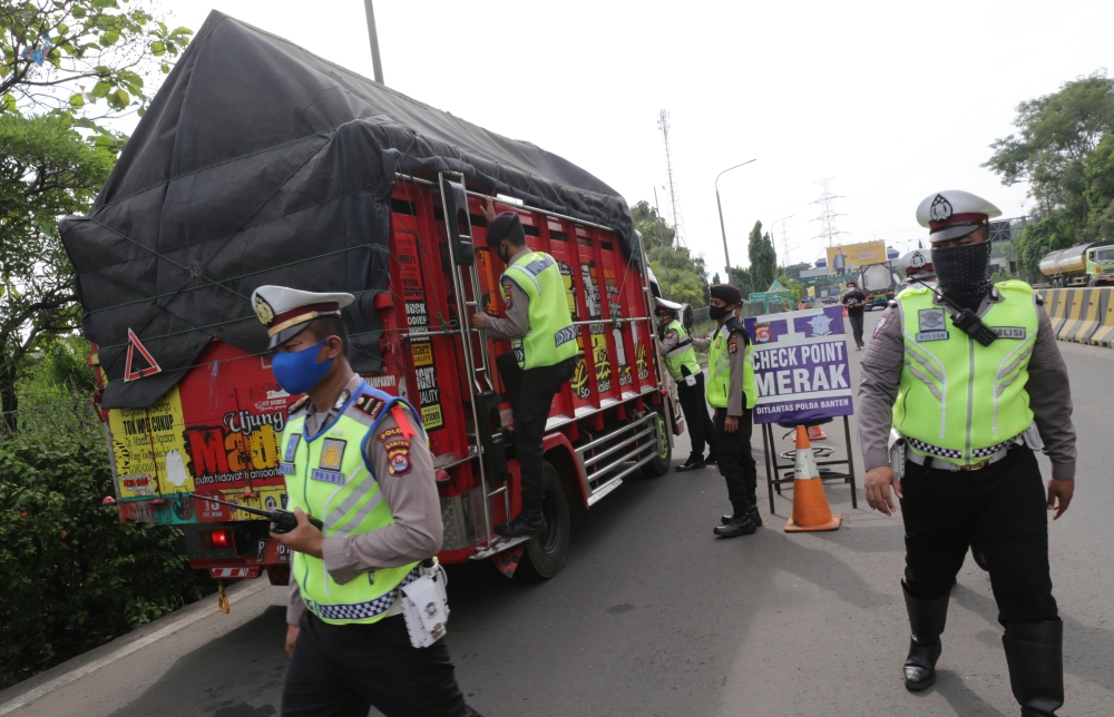 Police officers stop a number of vehicles passing at the entrance to the Merak Port in Cilegon, Banten, Indonesia on May 19, 2020.  Eko Siswono Toyudho - Anadolu 