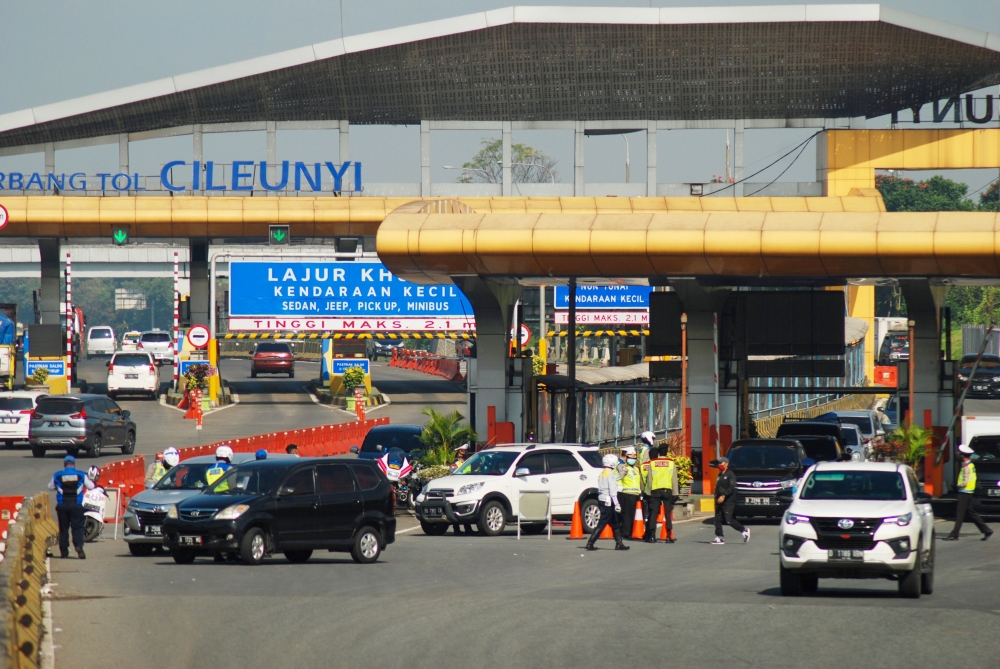 Indonesian police order some motorists who could not provide required travel documents to return at a check point in Bandung, West Java on May 20, 2020, during a partial lockdown amid concerns of the COVID-19 coronavirus pandemic as the government issued 