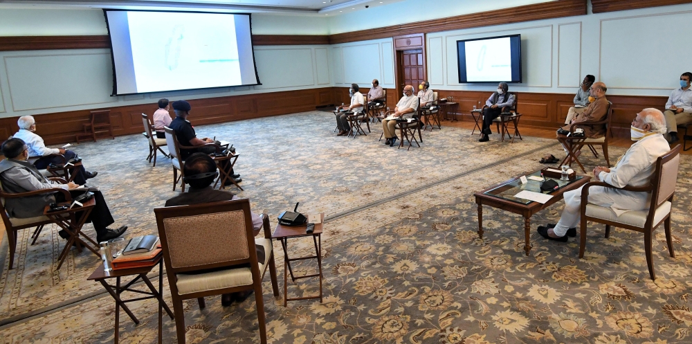 NEW DELHI, INDIA - MAY 18: ndian Prime Minister Narendra Modi (R), wearing a face mask as as a preventive measure against the coronavirus (COVID-19) pandemic, chairs a meeting to review the response measures against cyclone ‘Amphan’ developing in the Bay 