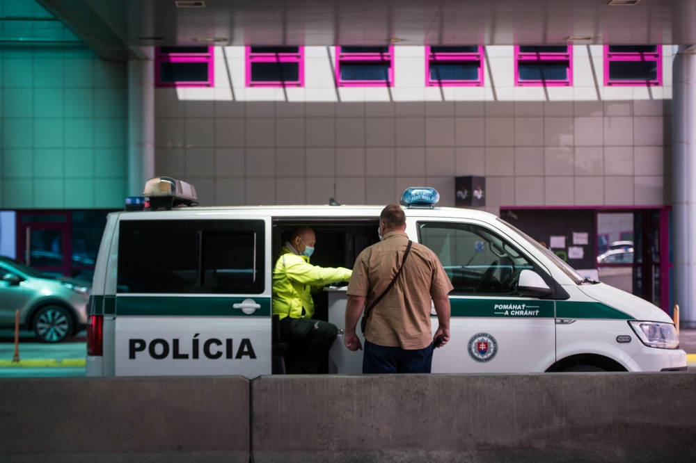 A Slovak policeman instructs a man who passes a Bratislava-Jarovce border crossing between Slovakia and Austria on May 21, 2020. AFP / VLADIMIR SIMICEK
