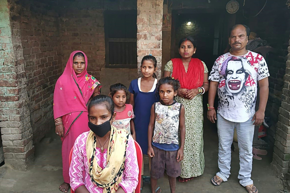 Jyoti Kumari Paswan (C-bottom) and her family stand in front of their house in Siruhully village at Darbhanga district, on May 23, 2020. AFP / STR
 