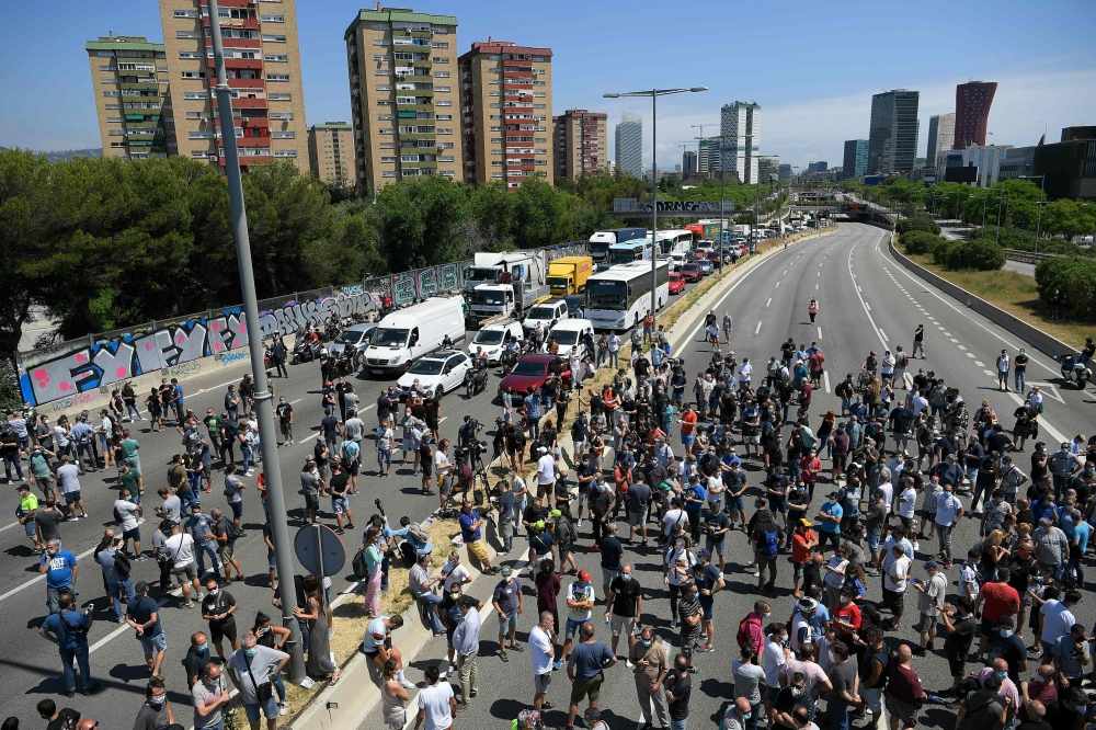 Nissan employees cut off one of the main entrances to Barcelona, as they protest against the closure of the Japanese cars manufacturer's plant in Barcelona on May 28, 2020.  AFP / LLUIS GENE