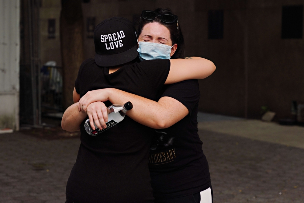 People embrace during the coronavirus pandemic on May 29, 2020 in New York City. Cindy Ord/Getty Images/AFP 