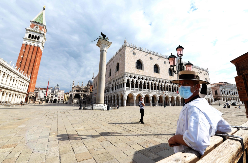 Gondoliere waits for tourists on May 30, 2020 in Venice, as the country eases its lockdown aimed at curbing the spread of the COVID-19 infection, caused by the novel coronavirus. / AFP / ANDREA PATTARO