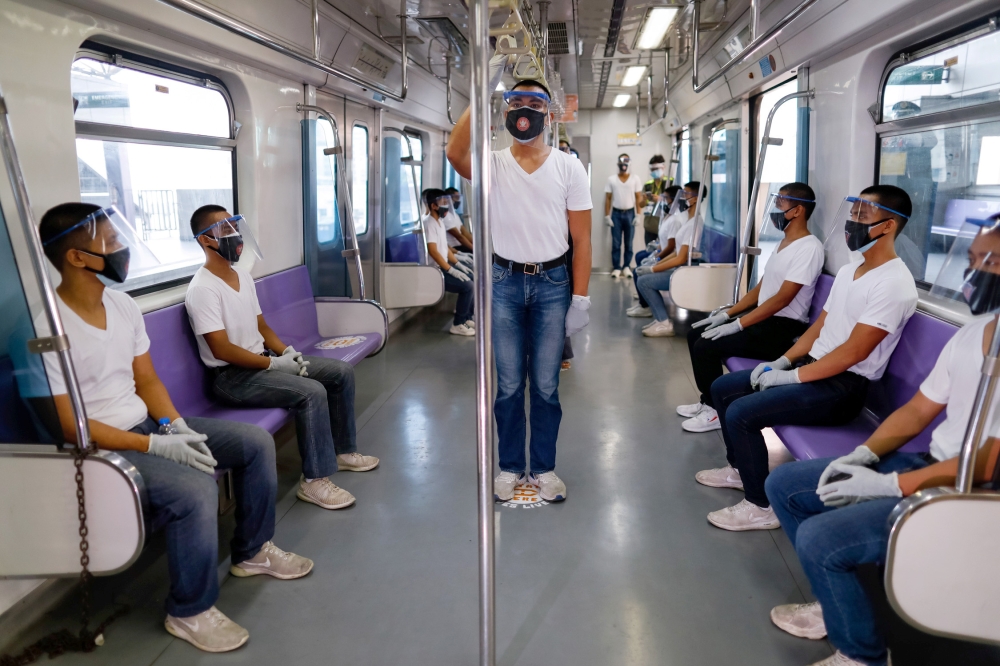 Police trainees wearing personal protective equipment maintain social distancing in a train during a simulation exercise in preparation for the resumption of train operations, amid the coronavirus disease (COVID-19) outbreak, in Manila, Philippines May 26