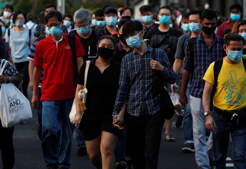 People cross a street during morning peak hour commute amid the coronavirus disease (COVID-19) outbreak in Singapore June 3, 2020. REUTERS/Edgar Su
