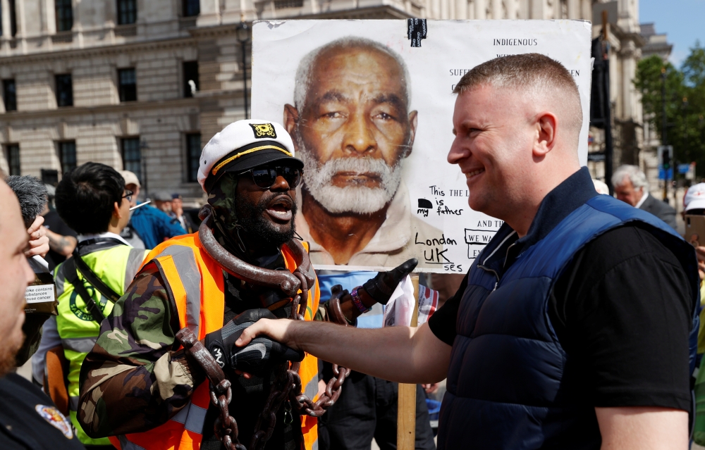 A demonstrator shakes hands with Paul Goulding, leader of a far-right political group Britain First, as they speak ahead of a Black Lives Matter protest following the death of George Floyd in Minneapolis police custody, in London, Britain, June 13, 2020. 