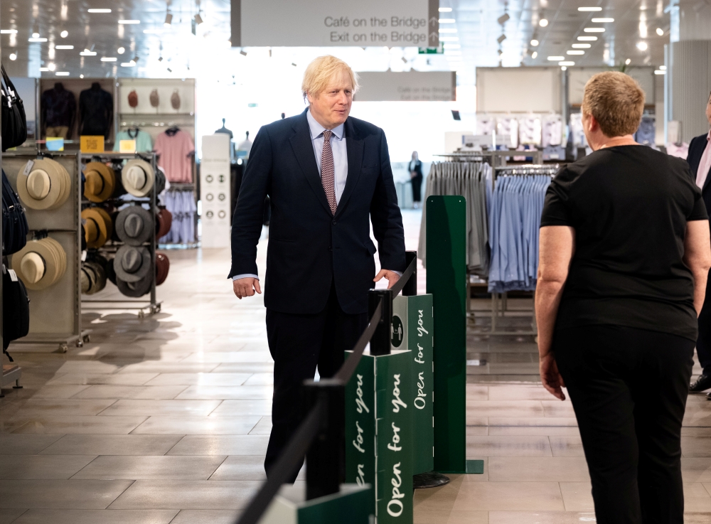 Prime Minister Boris Johnson speaks with a staff member as he visits the M&S clothing department and other retail outlets in Westfield Stratford to see the COVID-19 measure taken before reopening tomorrow, in London, Britain June 14, 2020. John Nguyen/Poo