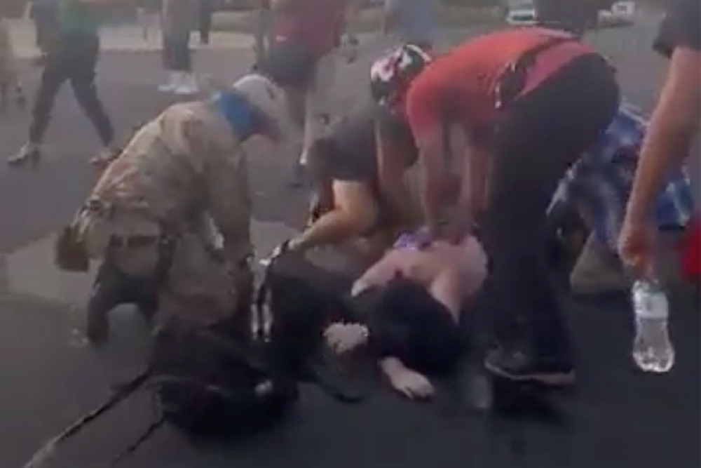 Attendees help a man who was shot and wounded during clashes between protesters trying to pull down a statue of Juan de Onate and armed members of civilian militia group New Mexico Civil Guard in downtown Albuquerque, New Mexico, U.S. June 15, 2020, in th