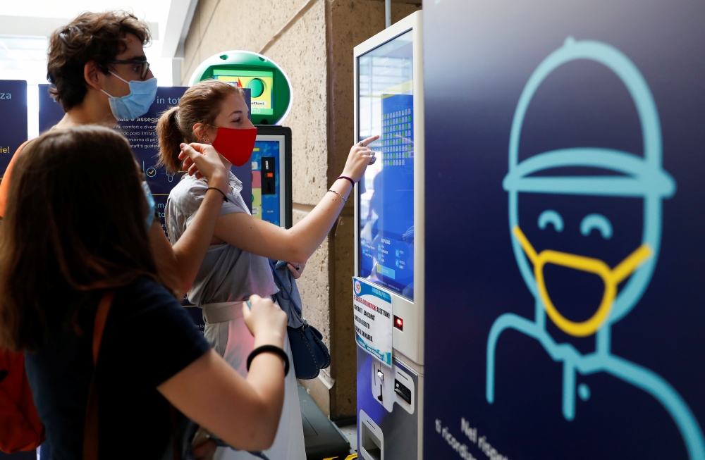 People wearing protective face masks choose seats at UCI Cinemas as Italy eases some of the lockdown measures put in place during the coronavirus disease (COVID-19) outbreak, in Rome, Italy June 15, 2020. REUTERS/Yara Nardi
