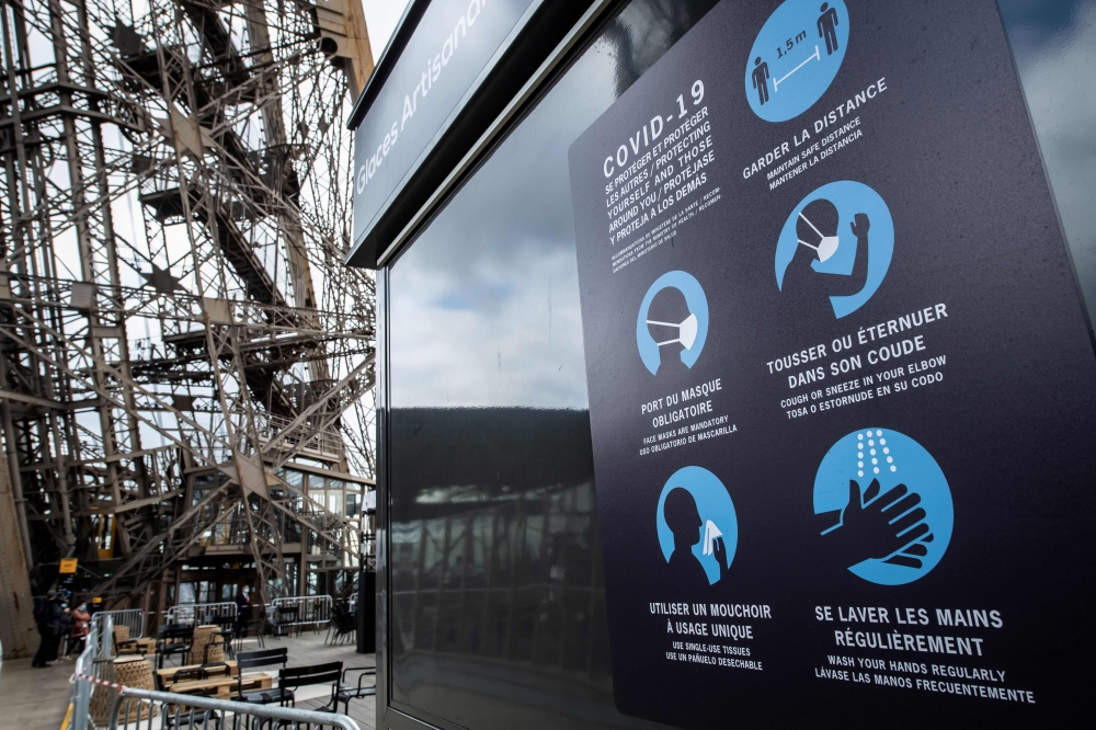 Sanitary instructions are seen on the waiting line to the Eiffel Tower, on June 15, 2020 in Paris, ahead of the partial reopening of the monument to the public as France eases lockdown measures taken to curb the spread of the Covid-19 pandemic (novel coro
