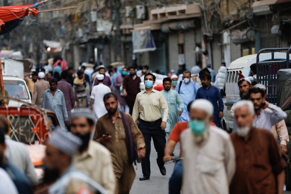 A man wears a protective face mask as he walks among other people along a street, as the outbreak of the coronavirus disease (COVID-19) continues, in Karachi, Pakistan June 16, 2020. REUTERS/Akhtar Soomro
