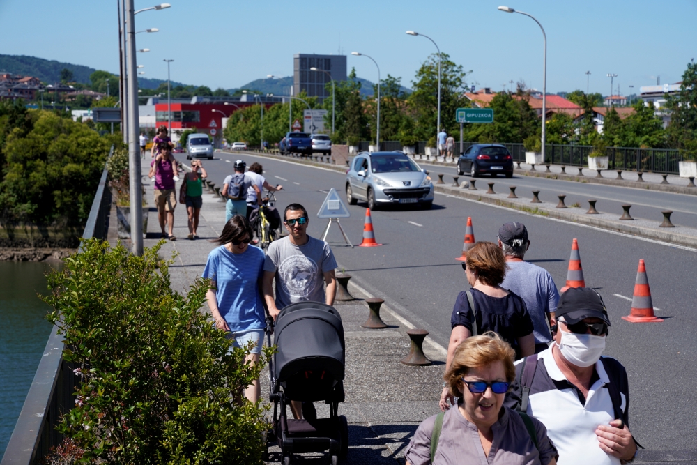 People walk on the Santiago bridge over the Bidasoa river separating Spain and France as Spain reopens its borders to most European visitors after the coronavirus lockdown coinciding with the end of the state of emergency in the country, in Irun, Spain Ju