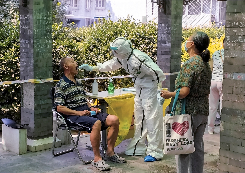 A man receives a nucleic acid test at a makeshift testing site in a residential compound after a new outbreak of the coronavirus disease (COVID-19) in Beijing, China June 21, 2020. REUTERS/Thomas Peter