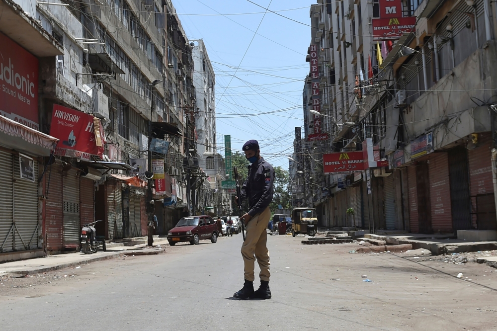 A policeman stands guard in a blocked street which was sealed by the authorities in Karachi on June 20, 2020, after the COVID-19 coronavirus cases continue to rise. / AFP / Rizwan TABASSUM