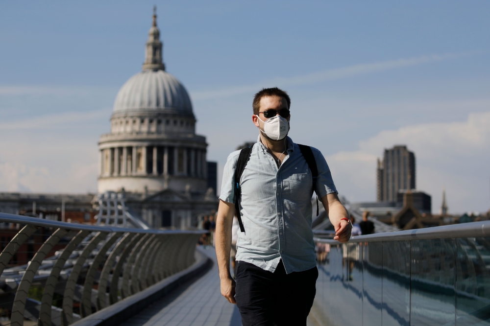 A pedestrian walks over The Millennium Bridge away from St Paul's Cathedral in London on June 26, 2020, as temperatures are expected to again be high, hitting 31 degrees Celsius in London. AFP / Tolga AKMEN