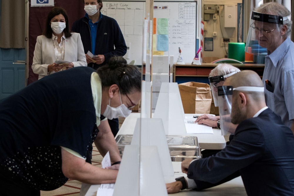 Paris Mayor Anne Hidalgo queue to cast her vote during the second round of the mayoral elections, delayed by more than three months due to the coronavirus disease (COVID-19) spread, at the Hotel de Ville in Paris, France June 28, 2020. Joel Saget/Pool via