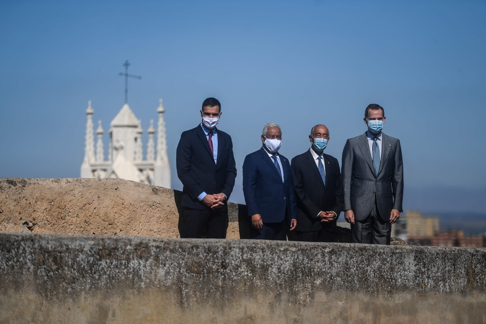 Portuguese President Marcelo Rebelo de Sousa (2R), Spain´s King Felipe VI (R), Portuguese Prime Minister Antonio Costa (2L) and Spanish Prime Minister Pedro Sanchez (L) wear face masks and wave during a ceremony for the reopening of the border between Spa
