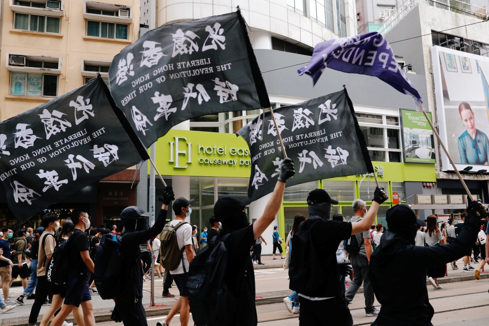 An anti-national security law protester holds a Hong Kong independence flag as he marches at the anniversary of Hong Kong's handover to China from Britain in Hong Kong, China July 1, 2020. REUTERS/Tyrone Siu