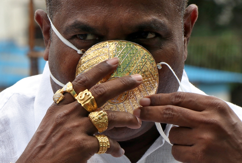 Shankar Kurhade (48), wears his face mask made out of gold as he poses for a photograph amidst the spread of the coronavirus disease (COVID-19) in Pune, India, July 4, 2020. REUTERS/Stringer 