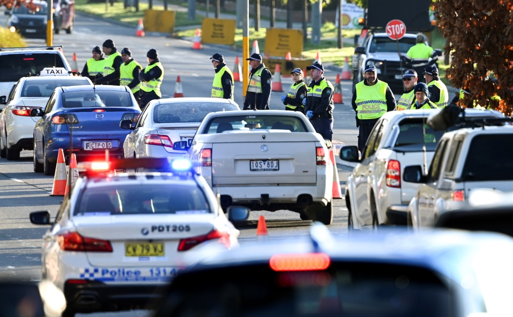 Police in the southern New South Wales (NSW) border city of Albury check cars crossing the state border from Victoria on July 8, 2020 after authorities closed the border due to an outbreak of COVID-19 coronavirus in Victoria. With the city of Melbourne go