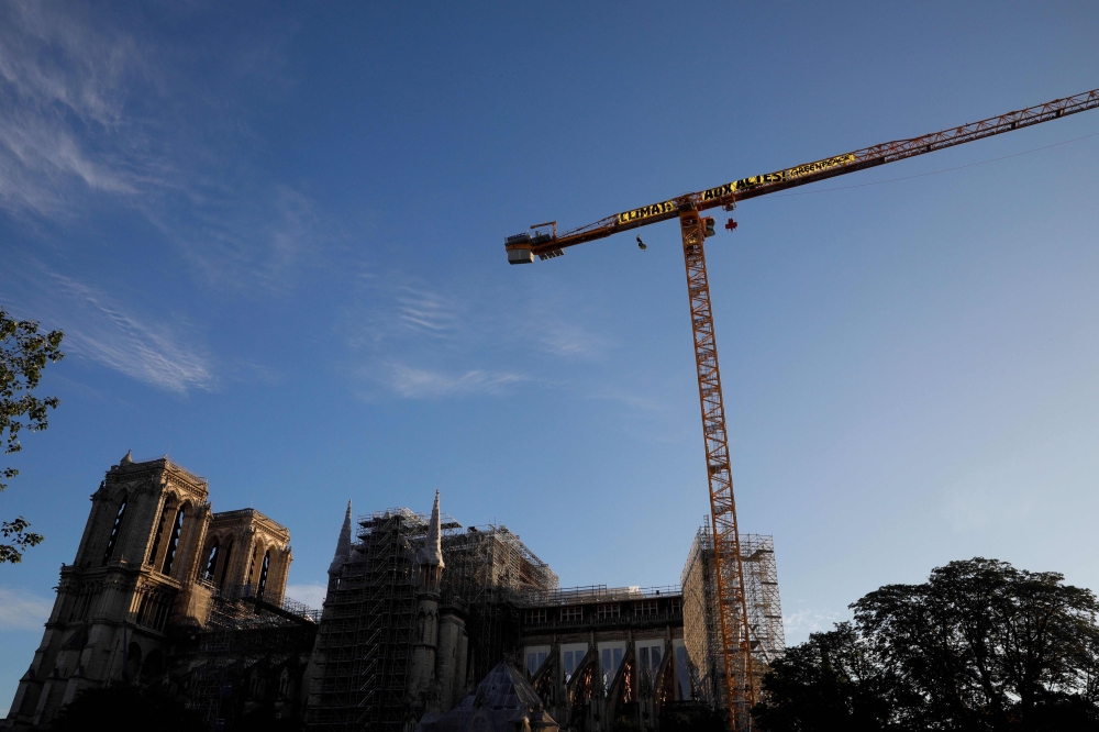 Greenpeace activists hang, on a crane, a giant banner reading 