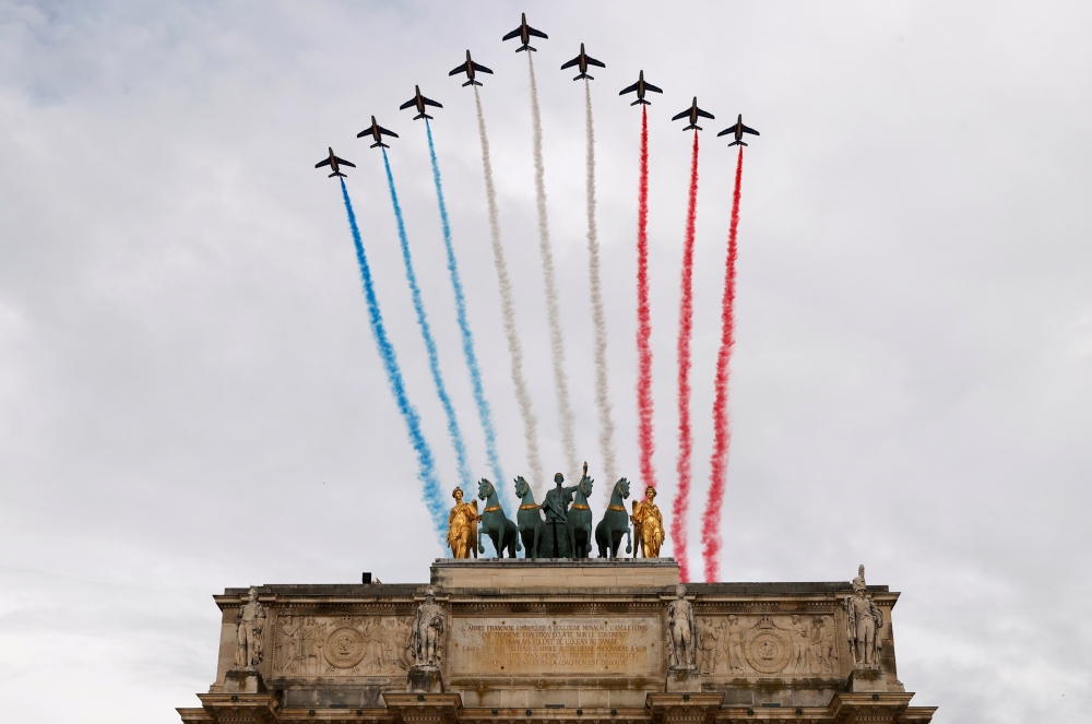 Alpha jets from the French Air Force Patrouille de France fly past the Arc de Triomphe du Carrousel, next to Le Louvre museum, during the Bastille Day celebrations in Paris, France, July 14, 2020. REUTERS/Christian Hartmann 