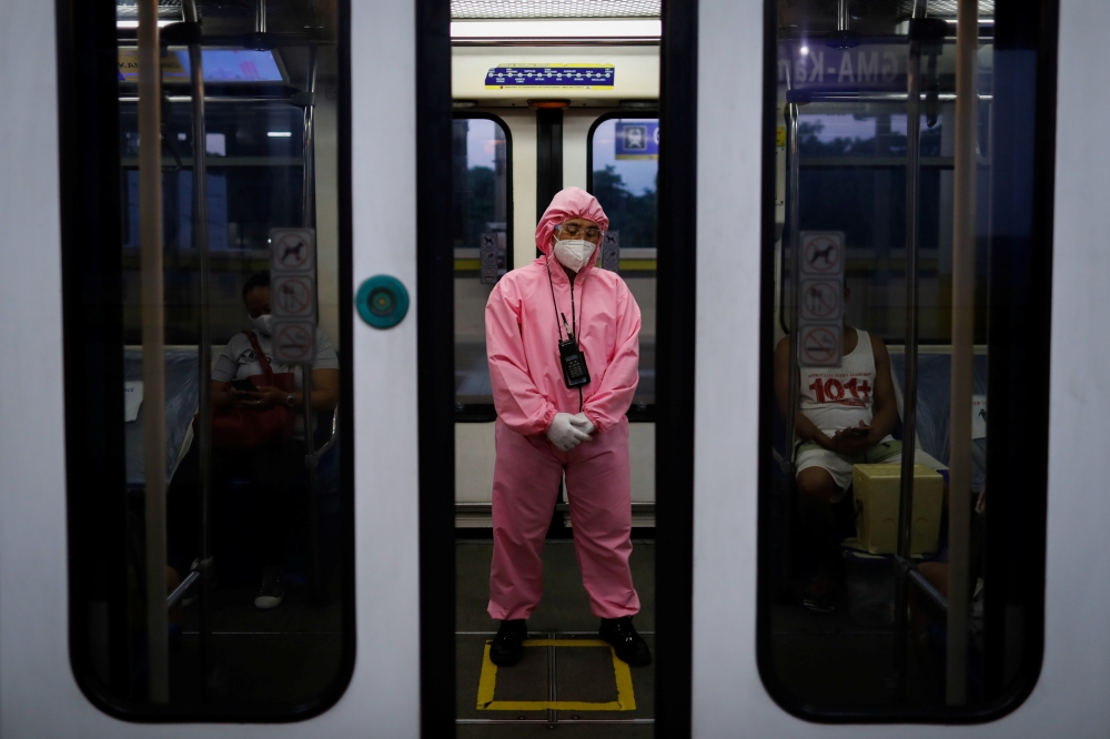 A train worker wearing personal protective equipment for protection against the coronavirus disease (COVID-19) stands inside an almost empty train, in Quezon City, Metro Manila, Philippines, July 14, 2020. REUTERS/Eloisa Lopez