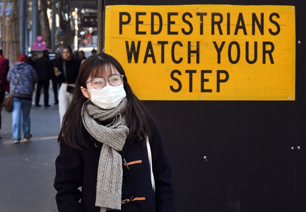 A pedestrian walks past a sign in Melbourne's central business district on July 16, 2020, as Australia announced 1.4 billion USD to retrain workers impacted by the coronavirus fallout, with unemployment rising to its highest level in more than two decades