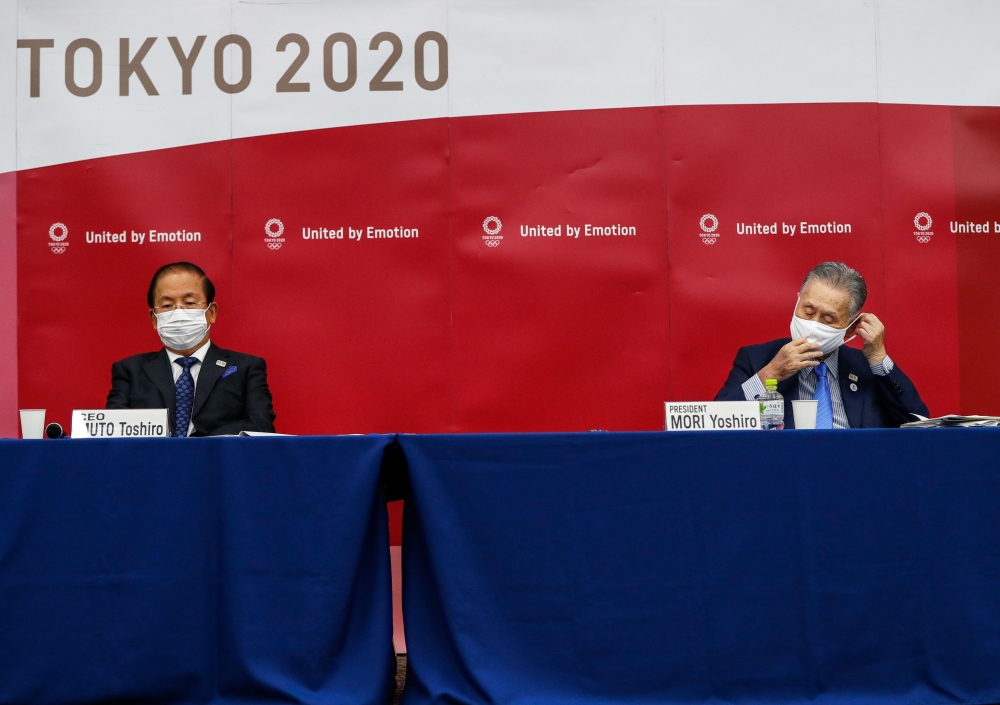 President of the Tokyo 2020 Organising Committee Yoshiro Mori (R), and Tokyo 2020 Organising Committee CEO Toshiro Muto, wearing face masks attend a news conference after giving a presentation to the International Olympic Committee (IOC) about the rearran