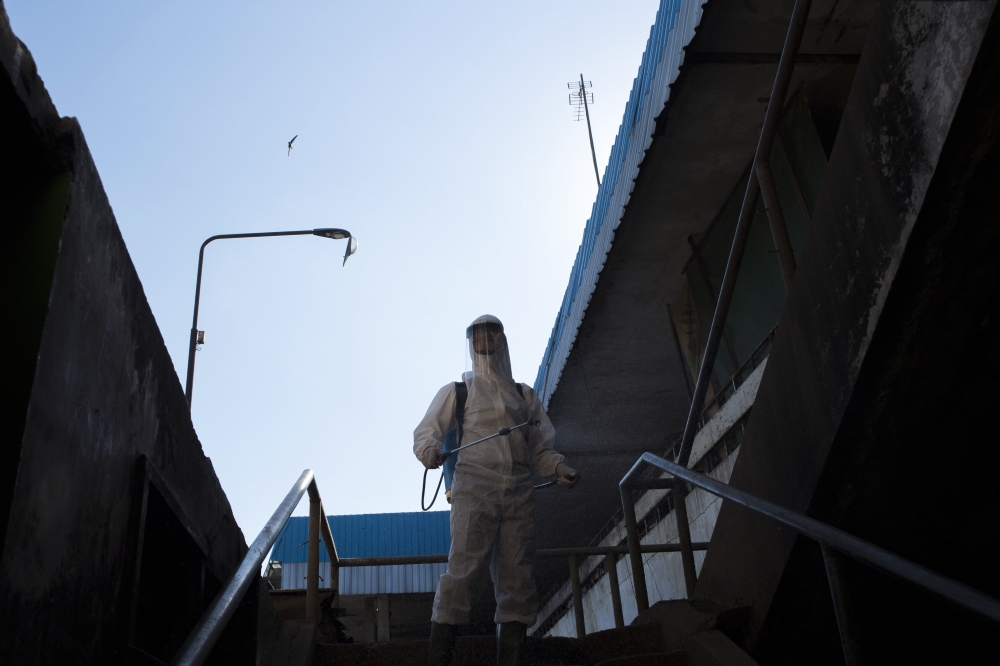 An Indonesian firefighter sprays disinfectant as a precautionary measure against the spread of the COVID-19 coronavirus in Surabaya on July 21, 2020. / AFP / Juni Kriswanto