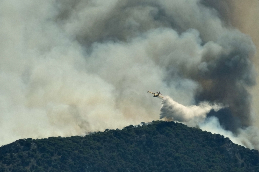A firefighting plane makes a water drop as a wildfire burns near the village of Kechries, Greece, July 22, 2020. REUTERS/Vassilis Triandafyllou 