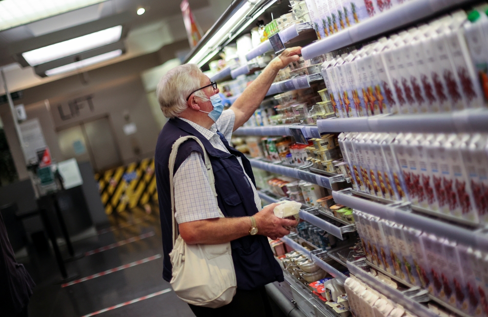 A man wears a protective mask in a shop under the new rules that enforce wearing face coverings in enclosed public spaces, amid the coronavirus disease (COVID-19) outbreak, in Hanley, Stoke-on-Trent, Britain July 24, 2020. REUTERS/Carl Recine