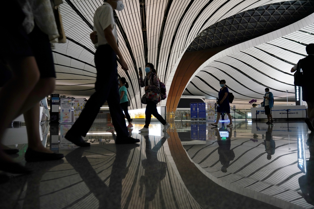 FILE PHOTO: People wearing face masks following the coronavirus disease (COVID-19) outbreak are seen at Beijing Daxing International Airport in Beijing, China July 23, 2020. REUTERS/Thomas Suen/File Photo