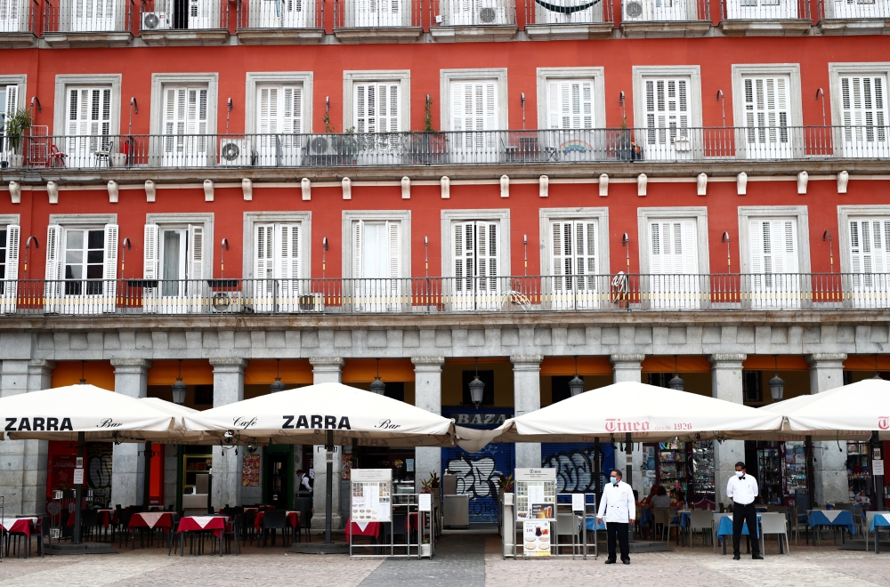 Waiters wearing protective masks wait for customers outside a restaurant amid the coronavirus disease (COVID-19) outbreak in Madrid, Spain July 28, 2020. REUTERS/Javier Barbancho