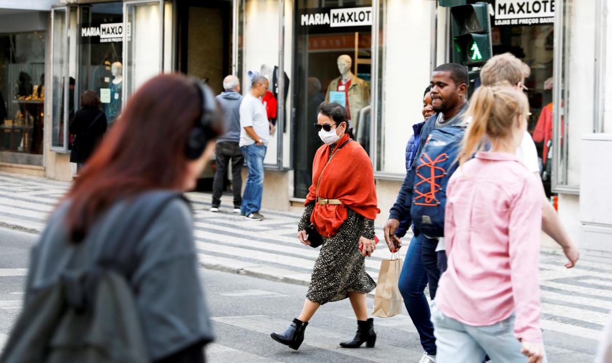 FILE PHOTO: A woman wearing a protective face mask, due to the coronavirus outbreak, walks in downtown Lisbon, Portugal March 12, 2020. REUTERS/Rafael Marchante
