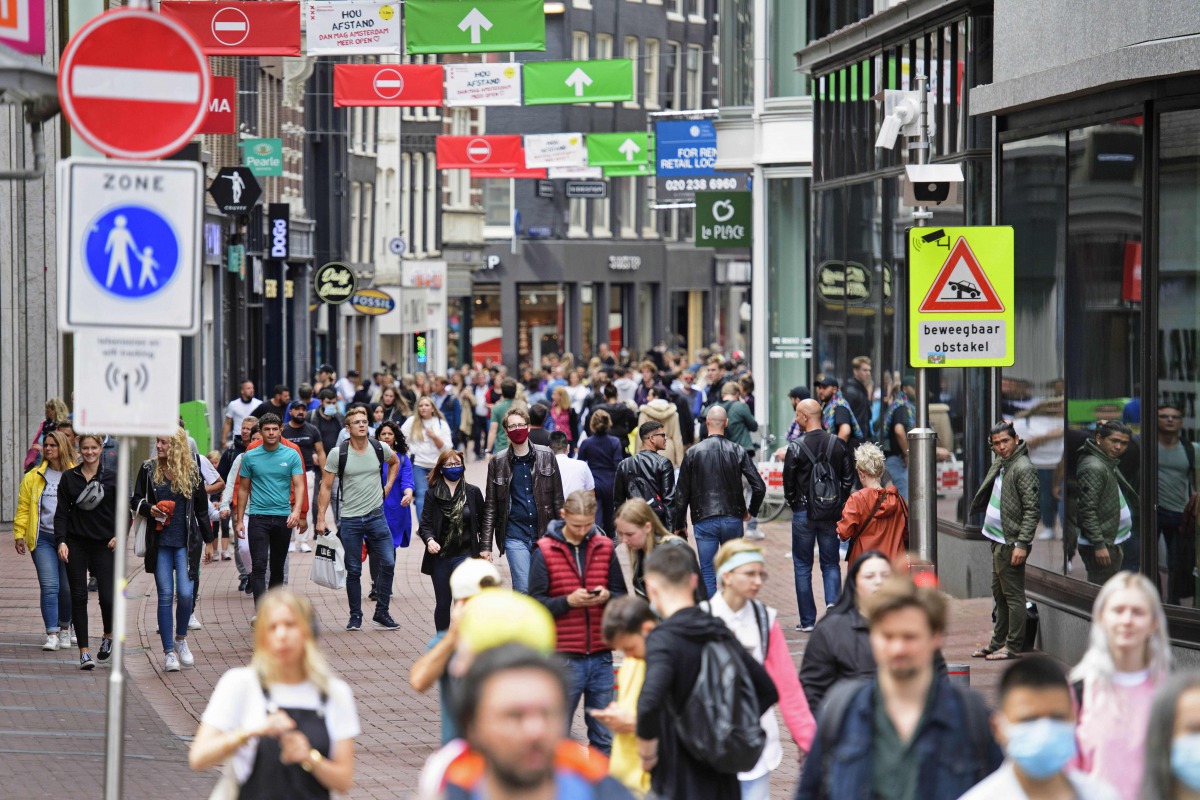 Tourists walk at Kalverstraat, a shopping street in AMSTERDAM on July 25, 2020 as the municipality has stricter supervision over the weekend and one-way traffic was set up for pedestrians on a certain section of the street due to the increasing number of 