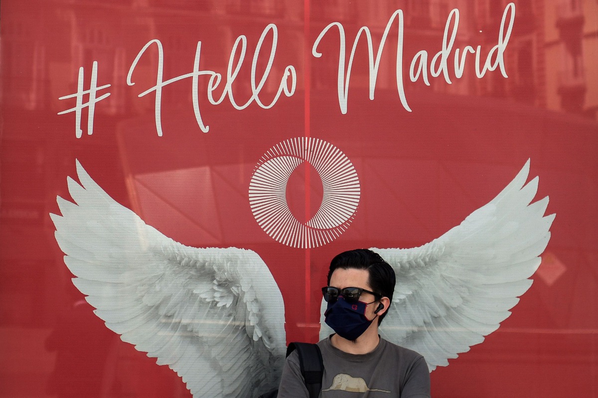 A man wearing a face mask stands outside a shop in Madrid on July 29, 2020. Madrid moved to make mask-wearing obligatory at all times in public as Spain grappled with the fallout from a spike in virus cases that has triggered several international travel 