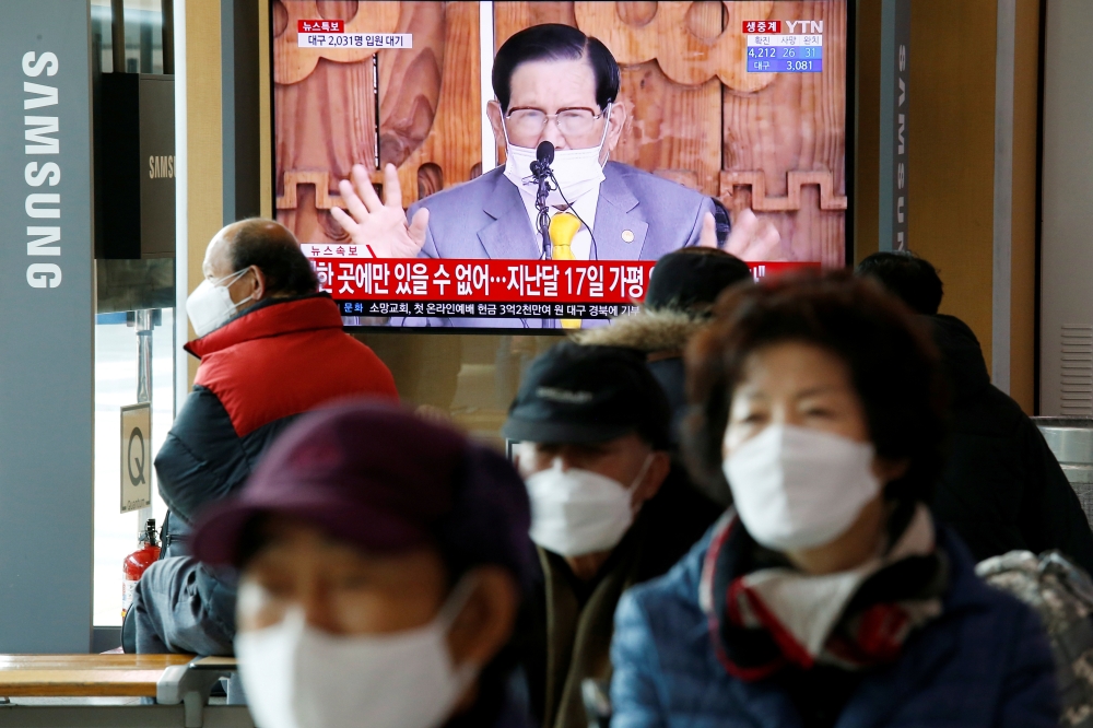 FILE PHOTO: People watch a TV broadcasting a news report on a news conference held by Lee Man-hee, founder of the Shincheonji Church of Jesus the Temple of the Tabernacle of the Testimony, in Seoul, South Korea, March 2, 2020. REUTERS/Heo Ran/File Photo