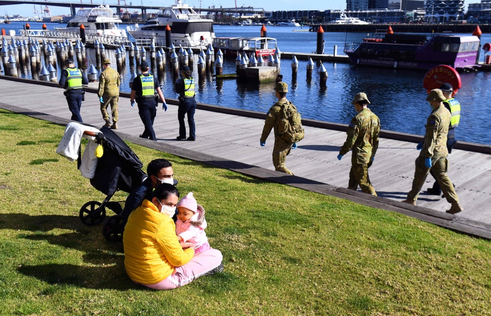 A group of police and soldiers patrol the Docklands area of Melbourne on August 2, 2020. AFP / William WEST
