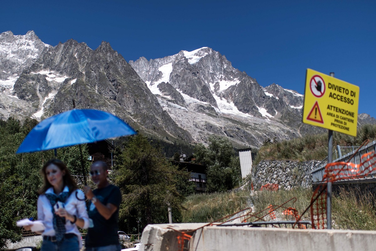 Journalists work next to a sign reading 