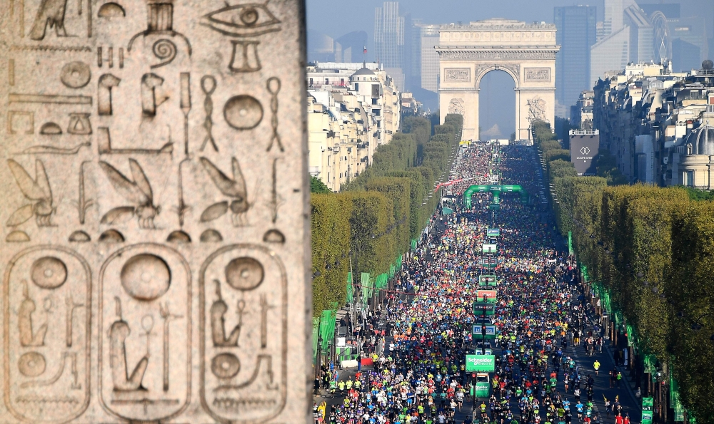 In this file photo taken on April 9, 2017 A detail of the Luxor Obelisk at the Place de la Concorde is seen as runners compete in the 41st Paris Marathon at the Champs-Elysees in Paris. The Paris marathon, scheduled for November 15, has been canceled due 