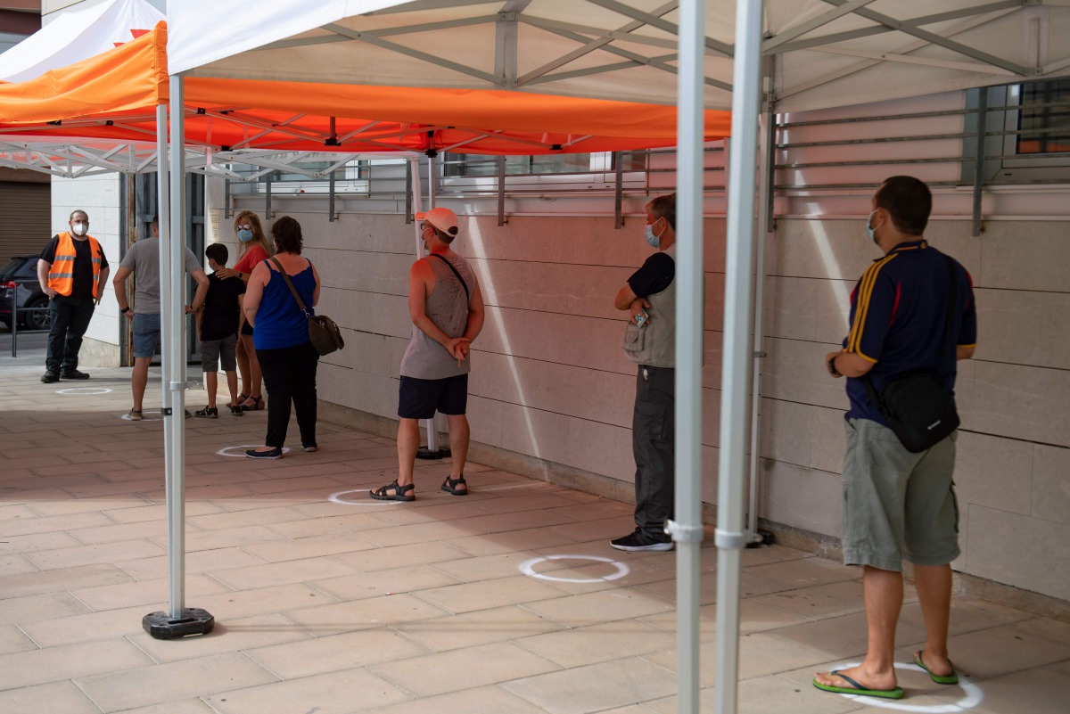 People queue outside a medical centre to be tested for the novel coronavirus in Santa Coloma de Gramenet, north of Barcelona, on August 10, 2020. Spain has added 19,405 new coronavirus cases in the past week, but the health ministry says the country is no