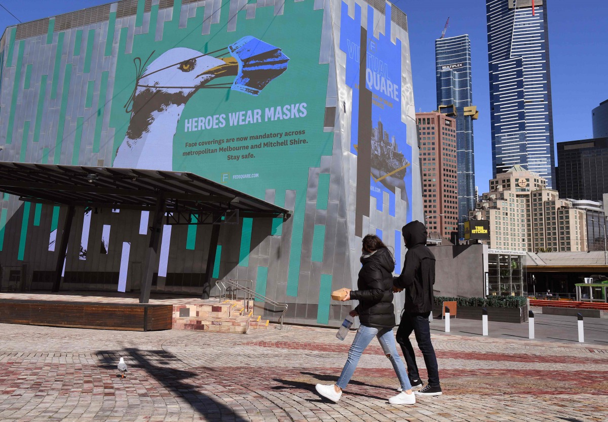 A sign in Federation Square urges people to wear a mask in the central business district in Melbourne on August 6, 2020./ AFP / William WEST