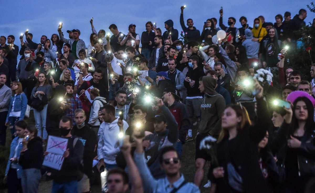 People wave their mobile phones during a protest rally against police violence during recent rallies of opposition supporters, who accuse strongman Alexander Lukashenko of falsifying the polls in the presidential election, in Minsk on August 13, 2020.  / 