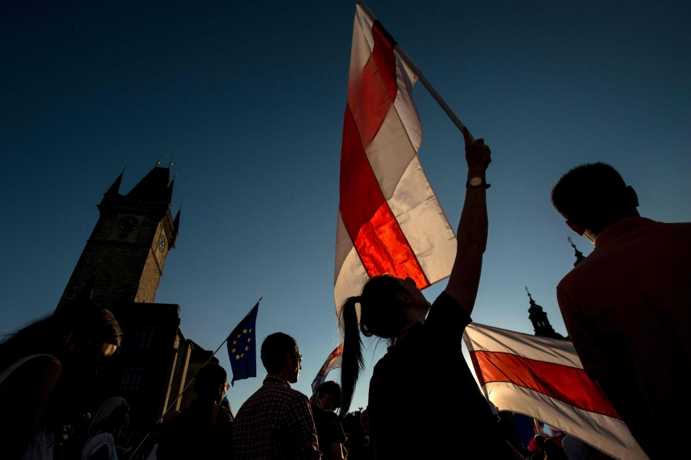 People holding Belarussian flags take part in a demostration in support of protests against the results of the Belarusian presidential election, on August 16, 2020 in Prague, Czech Republic. / AFP / Michal Cizek