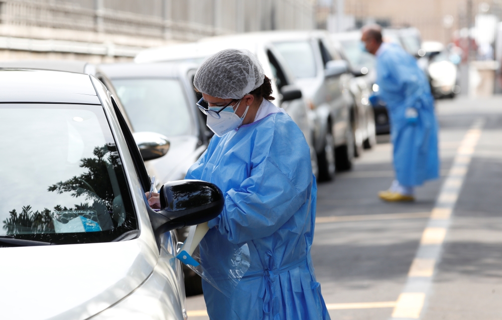 Healthcare workers register people at a coronavirus disease (COVID-19) drive in test centre at Rome's San Giovanni hospital in Rome, Italy, August 18, 2020. REUTERS/Remo Casilli