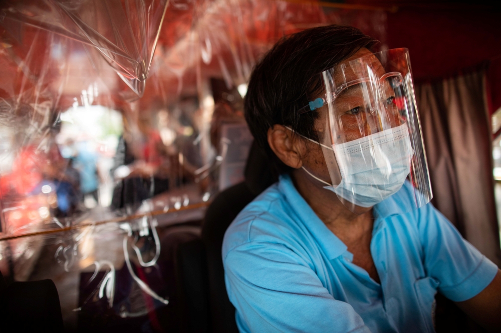 A jeepney driver wears a face mask and face shield, both mandatory in public transportation, to help curb coronavirus disease (COVID-19) infections, in Quezon City, Metro Manila, Philippines, August 19, 2020. REUTERS/Eloisa Lopez
