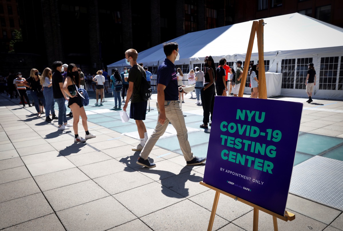 People wear protective masks as they wait in line at a testing site for the coronavirus disease (COVID-19) set up for returning students, faculty and staff on the main campus of New York University (NYU) in Manhattan in New York City, New York, U.S., Augu